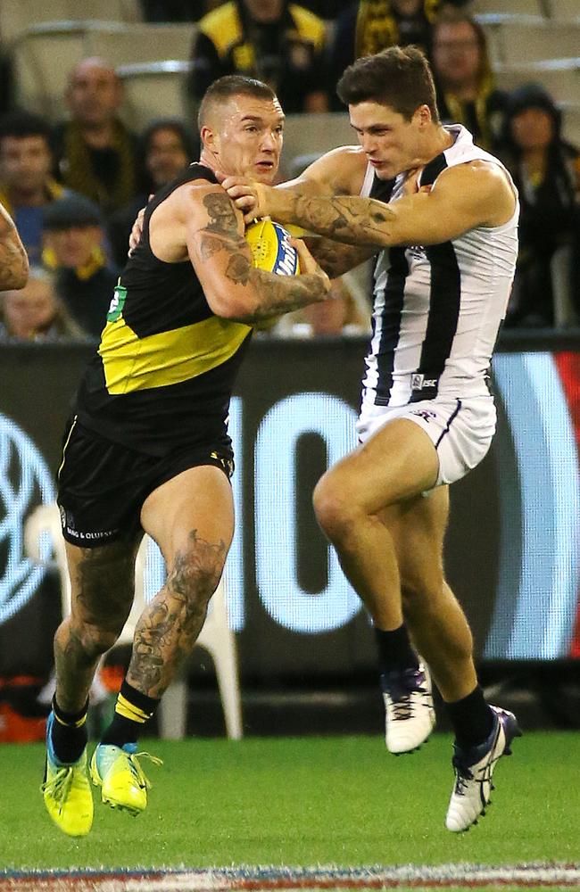 Dustin Martin fends off Collingwood’s Jack Crisp. Picture: George Salpigtidis