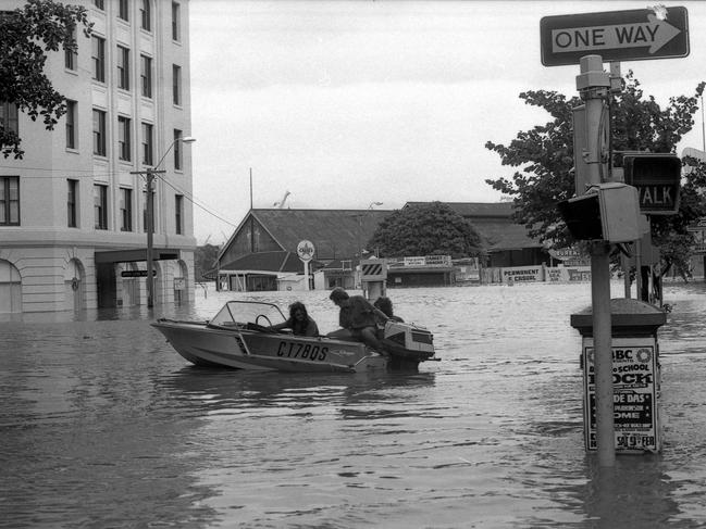 Small boats moving people trapped by flood waters in Edward Street, Brisbane. Picture by Geoff McLachlan The Courier-Mail Photo Archive. 30/1/ 1974