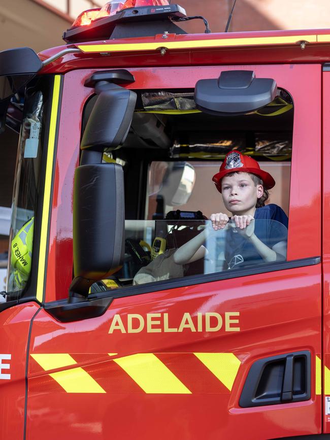 Best Book Week Costume winner, Texas Flynn with fire fighters Brett Maher and Mark Willoughby at Adelaide Station Picture: Kelly Barnes