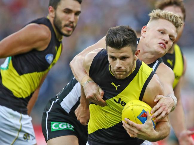 MELBOURNE, VICTORIA - APRIL 29:  Trent Cotchin of the Tigers is tackled during the AFL round six match between the Collingwood Magpies and Richmond Tigers at Melbourne Cricket Ground on April 29, 2018 in Melbourne, Australia.  (Photo by Scott Barbour/AFL Media/Getty Images)