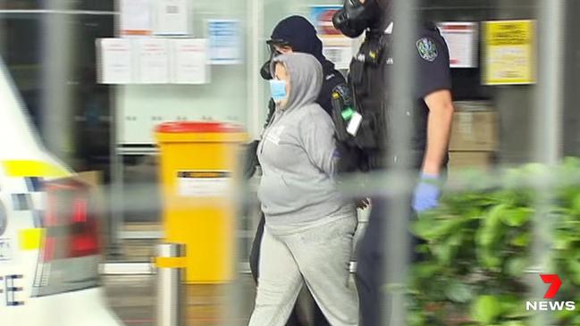 Police armed with a battering ram and bolt cutters have swarmed the Pullman medi-hotel, taking three people in handcuffs into custody. – Picture: 7NEWS