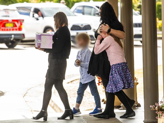 The mother of the three young children carries a small pink coffin, accompanied by her surviving children and a family friend. Picture: Jeremy Piper