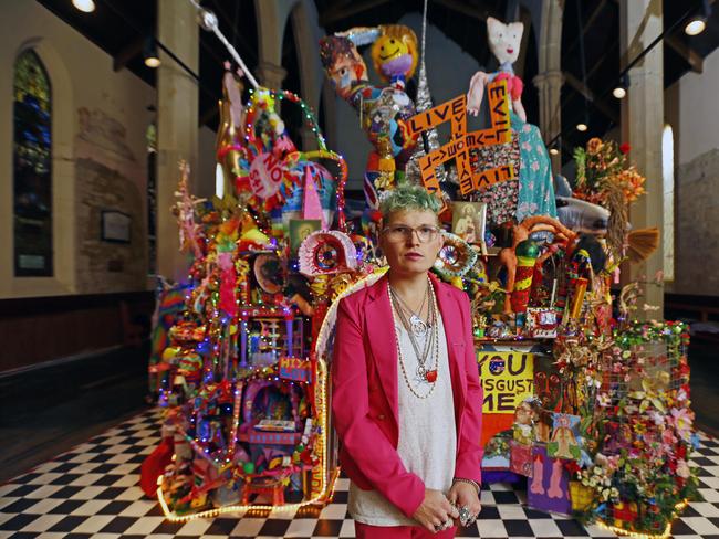 Paul Yore with his kaleidescopic rainbow-coloured sculptural temple within a church, constructed of found objects, toys, hand-made tapestry, sequins, and more. Picture: MATT THOMPSON