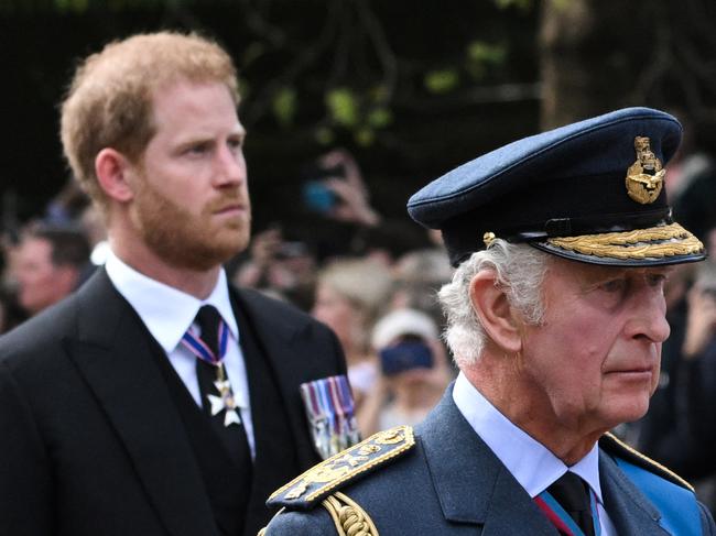 TOPSHOT - Britain's King Charles III and Britain's Prince Harry, Duke of Sussex walk behind the coffin of Queen Elizabeth II, adorned with a Royal Standard and the Imperial State Crown and pulled by a Gun Carriage of The King's Troop Royal Horse Artillery, during a procession from Buckingham Palace to the Palace of Westminster, in London on September 14, 2022. - Queen Elizabeth II will lie in state in Westminster Hall inside the Palace of Westminster, from Wednesday until a few hours before her funeral on Monday, with huge queues expected to file past her coffin to pay their respects. (Photo by LOIC VENANCE / AFP)