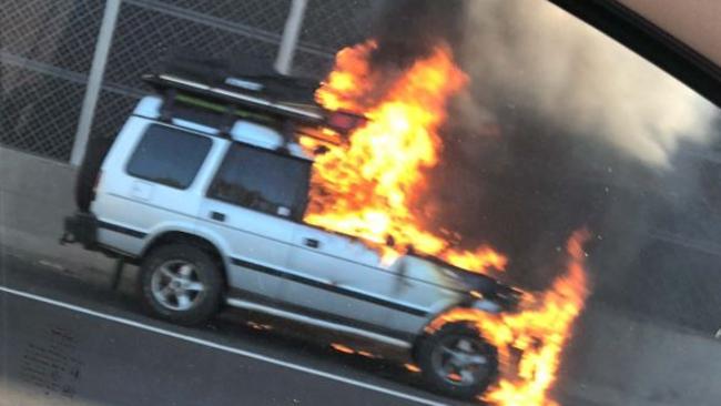 A 4WD on fire at the side of the Monash Freeway. Picture: Katherine Gallucci