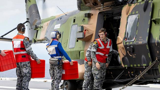 Royal Australian Navy sailors on HMAS Adelaide load disaster relief supplies onto a MRH-90 Taipan bound for Nabouwalu on the island of Vanua Levu, Fiji, during Operation Fiji Assist. PICTURE: Dept of Defence.