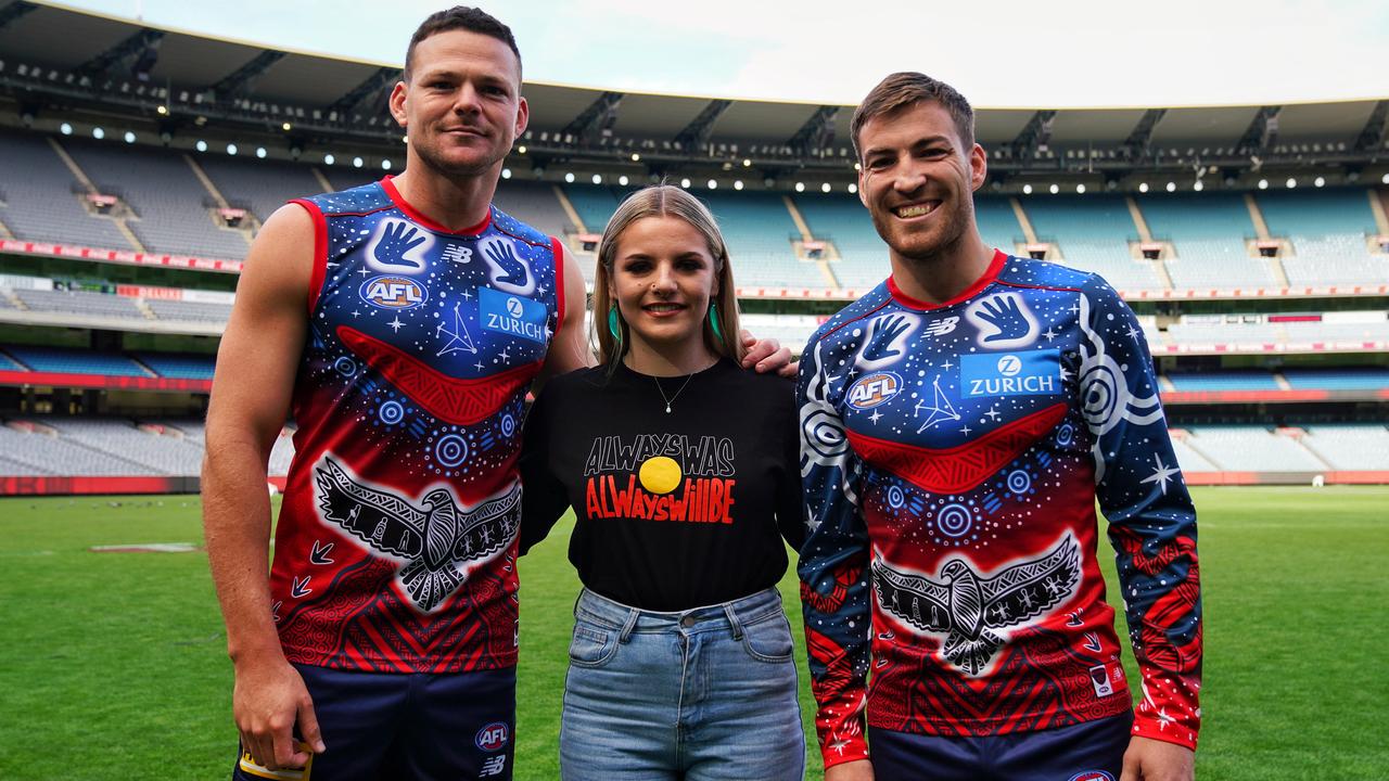 Melbourne stars Steven May (left) and Jack Viney (right) wear their club’s Indigenous round jumper, designed by Indigenous artist Ky-ya Nicholson Ward (centre). The club has also adopted its traditional Indigenous name, Narrm, for the Indigenous round. Picture: Ben Gibson/Melbourne Football Club
