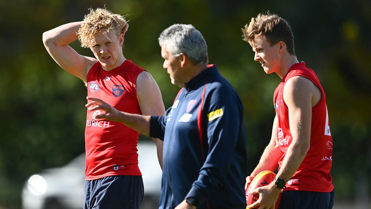 Clayton Oliver and James Jordan take advice from assistant coach Mark Williams on the training track.