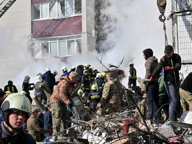 Rescuers and residents search for survivors in the rubble next to a damaged residential building in Uman, south of Kyiv on April 28, 2023, after Russian missile strikes targeted several Ukrainian cities overnight. - Ukraine and Russia have been fighting since Moscow's February 2022 invasion and Ukraine says it has been preparing for months a counter-offensive aimed at repelling Russian forces from the territory they currently hold in the east and south. (Photo by Sergei SUPINSKY / AFP)