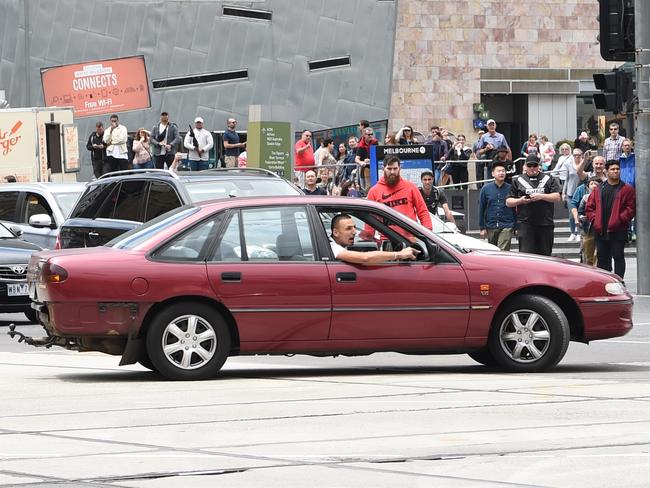 The driver, who is believed to have been involved in a stabbing incident earlier in the day, leans out of the window before driving on to a footpath crowded with shoppers at Bourke St Mall. Picture: Tony Gough