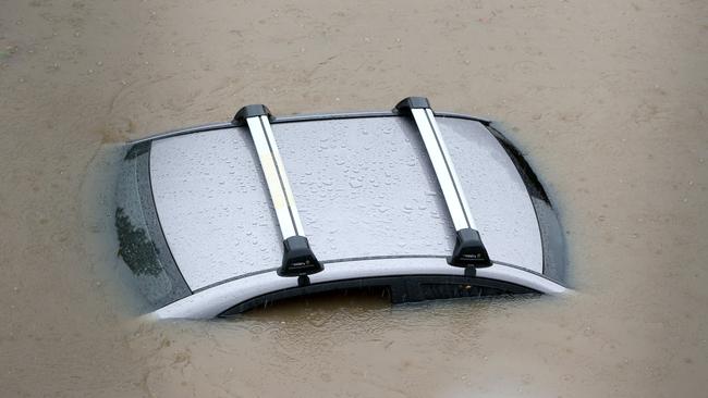 Floodwaters up to the roof of a car at Robina Hospital. Picture: NIGEL HALLETT