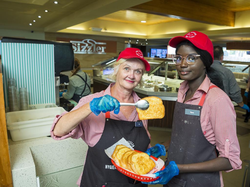 Staff members Niki Ryan (left) and Abul Deng serve Sizzlers iconic cheesy toast on the last day of trading before Sizzler restaurants close, Sunday, November 15, 2020. Picture: Kevin Farmer