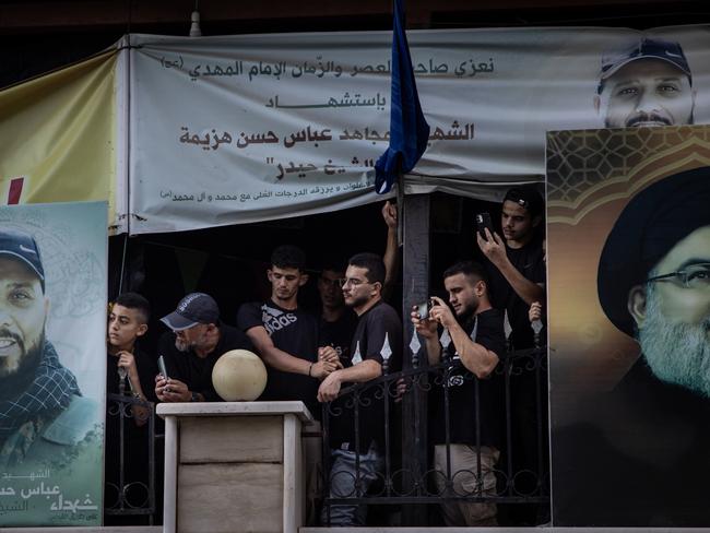 MAYS AL-JABAL, LEBANON - AUGUST 24: Men wait at the towns cemetery for the arrival of the coffin of Hezbollah fighter Husein Mohamad Choukair who was killed in an Israeli drone strike in southern Lebanon on August 23, during his funeral on August 24, 2024 Mays Al-Jabal, Lebanon. The recent assassination of a Hezbollah military commander in Lebanon, as well as the killing of the political leader of Hamas in Iran, has heightened concerns of a wider regional war between Israel and Iran-backed enemies like Hezbollah. Israel and Hezbollah have traded regular cross-border fire since Oct. 7, although both sides have seemed to calculate their attacks to avoid all-out war. (Photo by Chris McGrath/Getty Images)