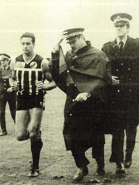 David Granger is escorted off the ground by police after the fiery 1982 preliminary final between Port Adelaide and Glenelg.