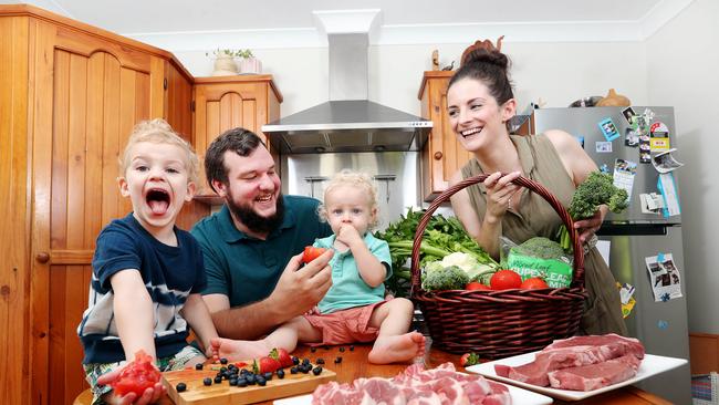 Brent and Stephanie Mlady at home with sons Oscar, 3, and Louis, 1, and produce which has increased in price due to extreme weather conditions. Picture: Tara Croser