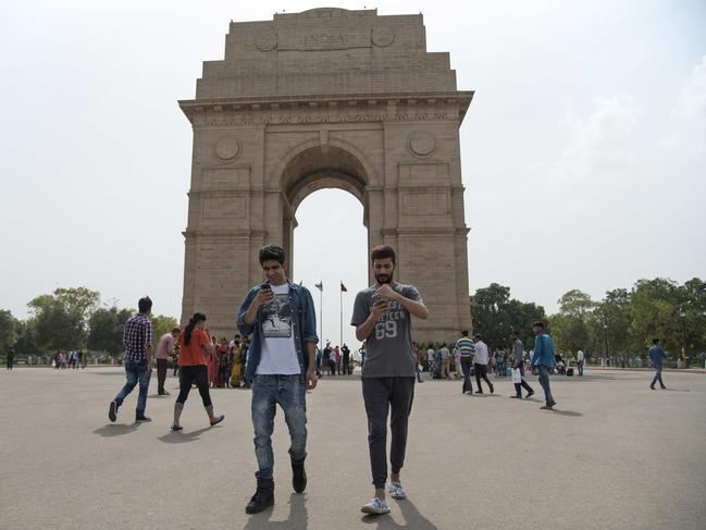 Shivanu Mandal and Geet Singh look at their screens as they play Pokemon Go in front of the landmark India Gate monument in New Delhi. Picture: AP