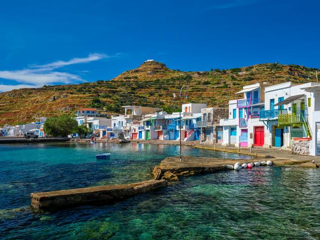 Scenic picturesque greek fishing village Klima with whitewashed traditional houses and colorful windows and doors on Milos island in Greece. For T+L alternative destinations.