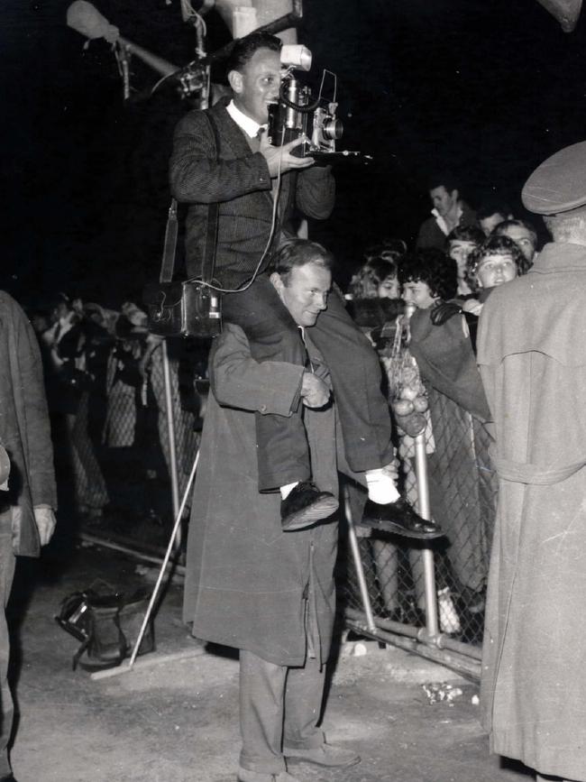 Photographer Bob Barnes on shoulders of Dave Schmidt, a courier photograhper, at arrival of The Beatles Picture. Picture: News Corp