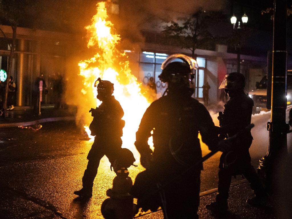 Portland police walk past a fire started by a Molotov cocktail thrown at police on September 23. Picture: Nathan Howard/Getty Images/AFP