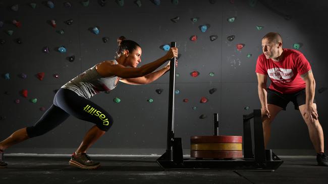 Northern Beaches mum Nikki Gordon works the weights under the watchful eye of Joe Bonington. Picture: Martin Lange