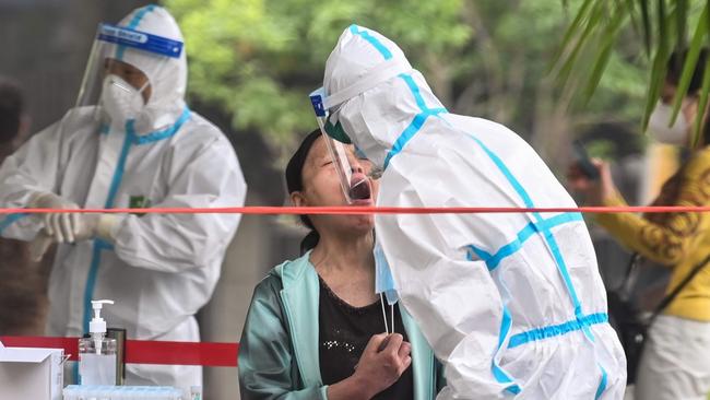 A medical worker takes a swab sample from a man to be tested for the COVID-19 novel coronavirus in a neighbourhood in Wuhan, in China’s central Hubei province on May 15. Picture: Hector Retamal/AFP