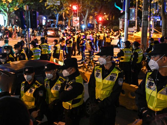 Police officers block Wulumuqi street, named for Urumqi in Mandarin, in Shanghai on November 27, 2022, in the area where protests against China's zero-Covid policy took place the night before following a deadly fire in Urumqi, the capital of the Xinjiang region. (Photo by Hector RETAMAL / AFP)