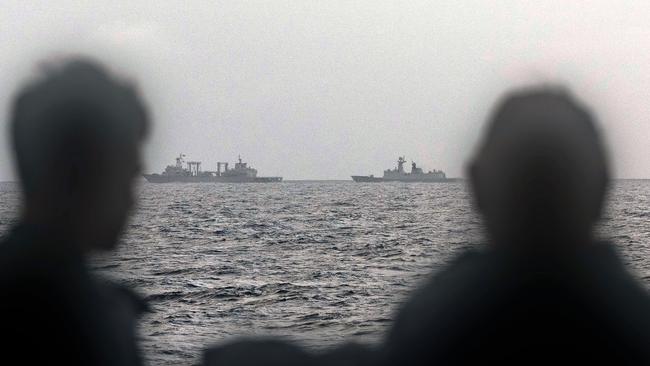 Australian Sailors aboard HMAS Arunta look at three Chinese warships sailing off the country's east coast in February. Picture: Australian Defence Force / AFP