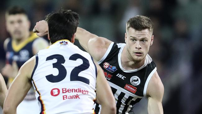 Port young gun Peter Ladhams attempts to get around Crow Darcy Fogarty at Adelaide Oval on Saturday. Picture SARAH REED