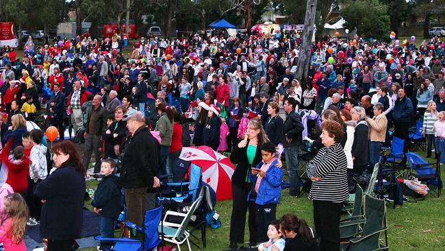 A big crowd enjoys Carols by Candlelight at Ruffey Lake Park.