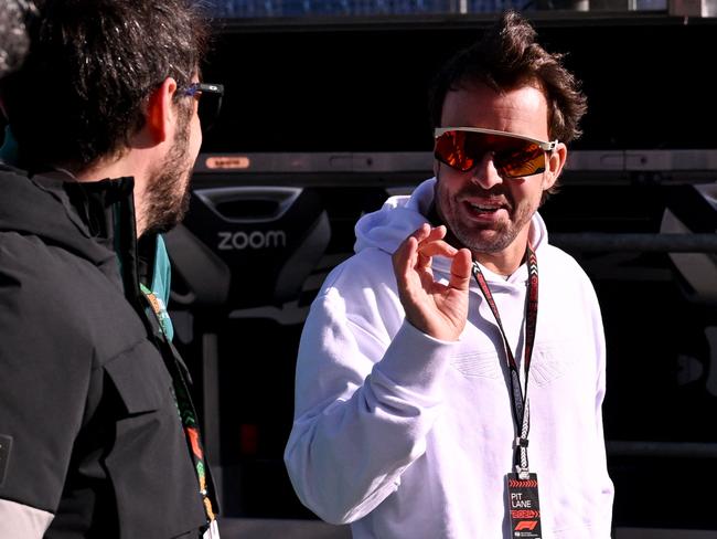 Aston Martin's Spanish driver Fernando Alonso (R) walks around the Albert Park circuit. Picture: AFP