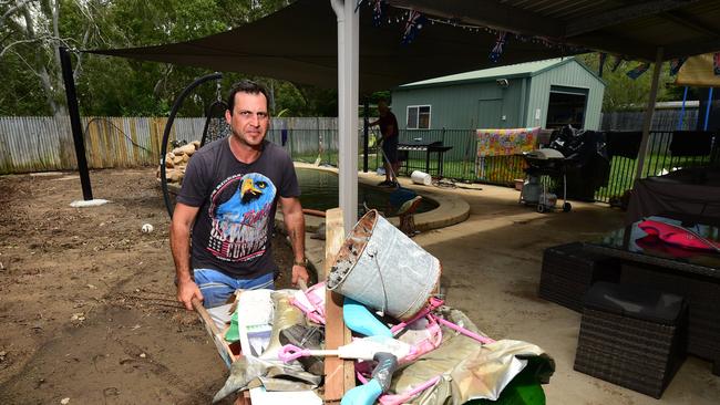 Flooding in Laura Court, Deeragun. Daniel Hanran clears water damaged items from his house. Picture: Evan Morgan