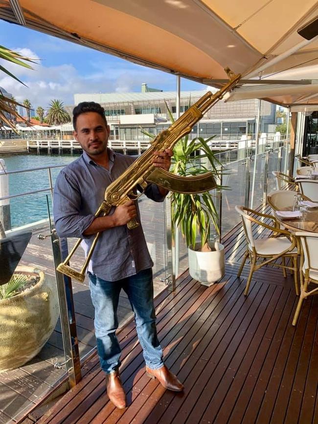 Arshdeep Khakh poses with a golden replica AK-47