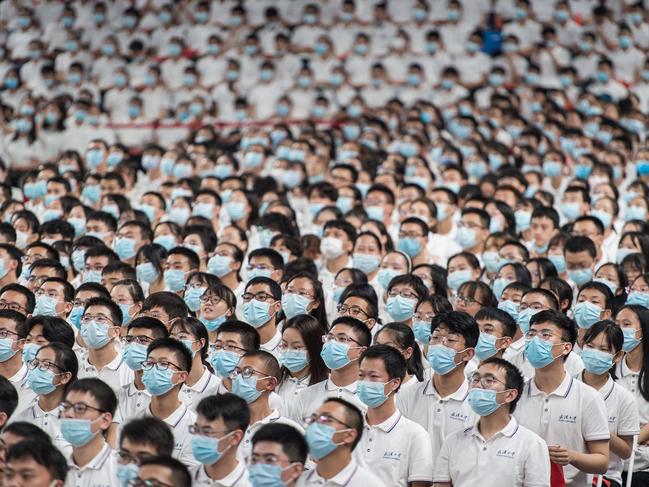 TOPSHOT - This photo taken on September 26, 2020 shows first-year students wearing masks as a preventive measure against the Covid-19 coronavirus during a commencement ceremony at Wuhan University in Wuhan, in China's central Hubei province. (Photo by STR / AFP) / China OUT