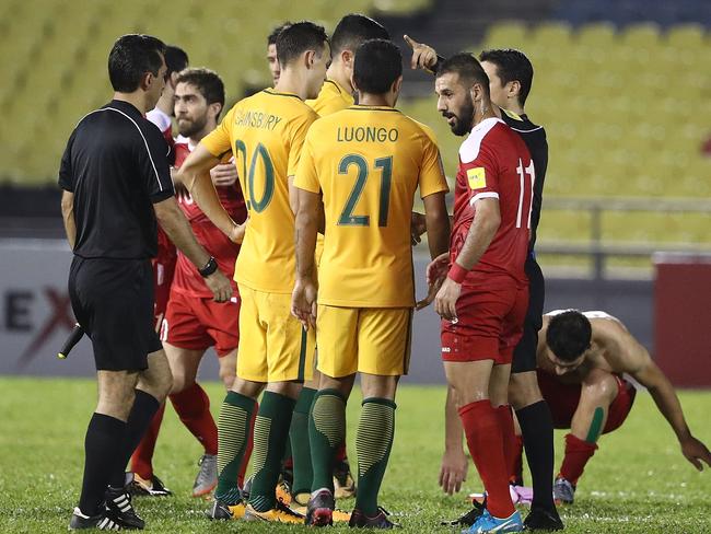 Australian players talk to referee Alireza Faghani after the penalty decision