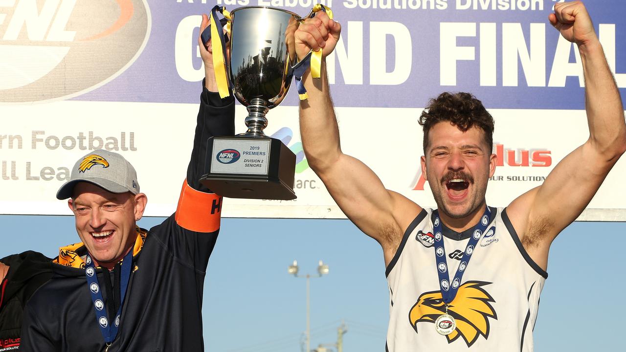 Whittlesea coach Blair Harvey and captain Riley Dyson lift the NFL Division 2 premiership trophy. Picture: Hamish Blair