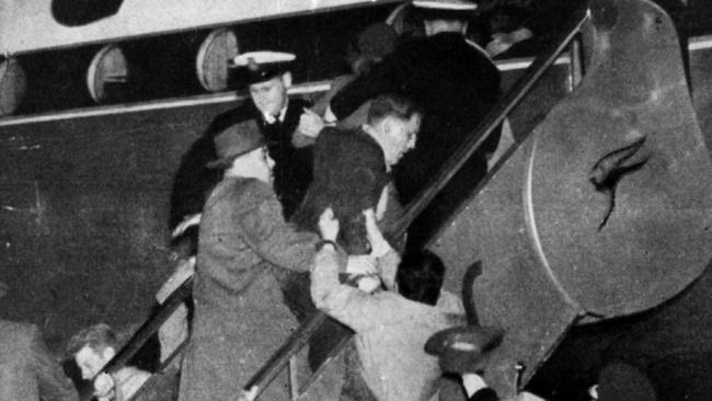 A protester grabs at one of the KGB agents as Mrs Petrov is bundled up the stairs to the aircraft.