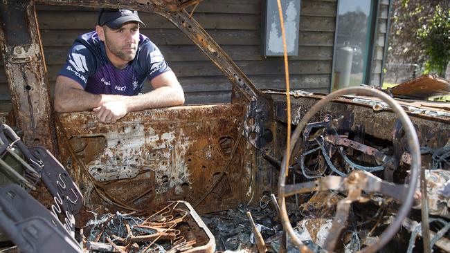 Melbourne Storm captain Cameron Smith checks out a burnt out car that was only a metres from the Bob and Virginia King's house in Sarsfield. Picture: Michael Klein.