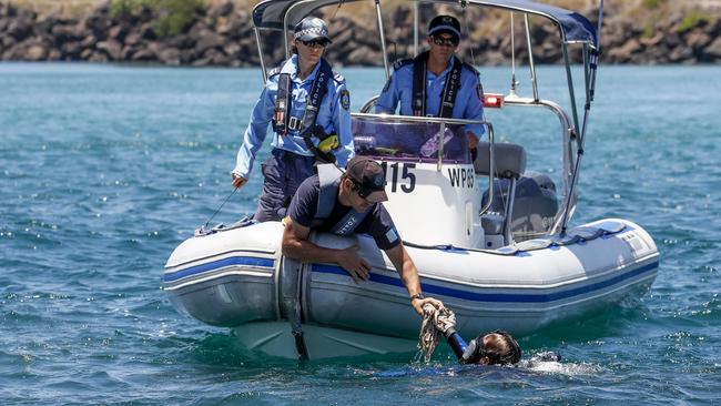 An object is handed to a police officer from a police diver searching the seabed along the Tweed River, Monday, November 26, 2018. (AAP Image/Tim Marsden) 