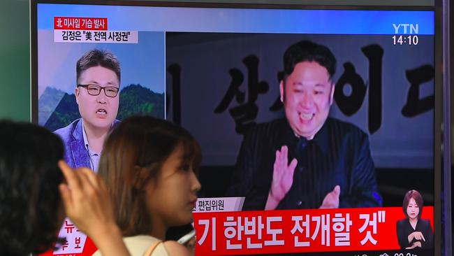 A woman walks past a television screen showing a video footage of North Korean leader Kim Jong-un celebrating his country's latest test launch of an intercontinental ballistic missile in Seoul. Picture: Jung Yeon-Je/AFP