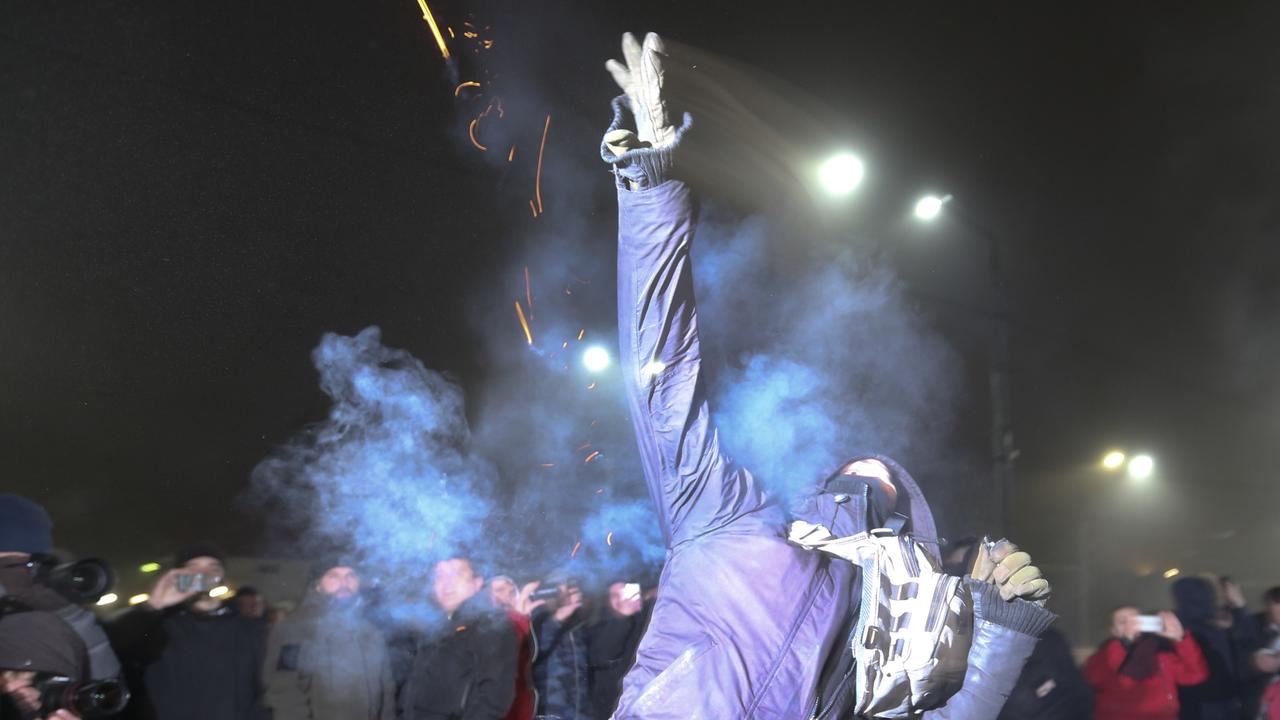 A protester throws a smoke grenade during a rally in front of the embassy of Russia in Kiev, Ukraine. Picture: AP