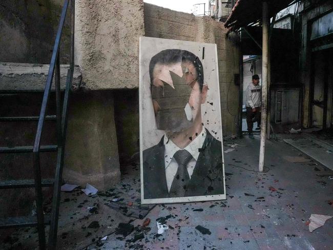 TA defaced portrait of ousted Syrian president Bashar al-Assad stands in a ransacked government security facility in Damascus. Picture: AFP