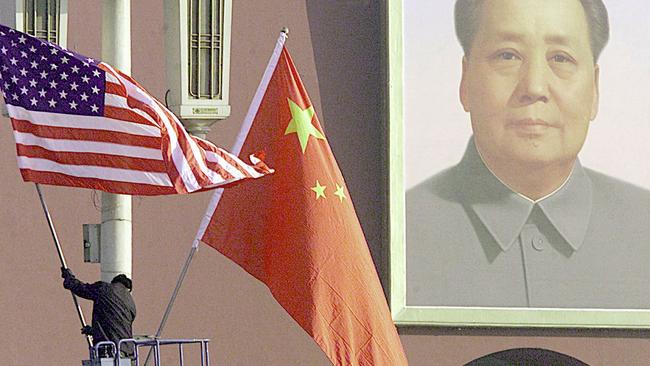 A worker hanging the national flags of the US and China at Tiananmen Square in Beijing for a visit by then-US President George W. Bush.