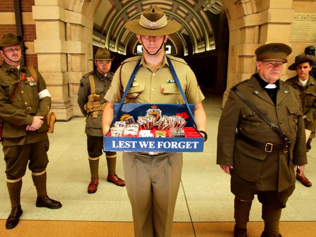 Lance corporal Chris Busic holding tray for Remembrance day at Central Station, with members of the 18th Battalion Living History Group. Picture: Ross Schultz