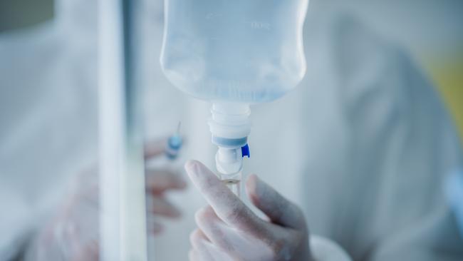 medicine health disease treatment concept, doctor injection liquid drug to saline bag in hospital room, drip treatment intravenous infusion, clinic health care medical concept