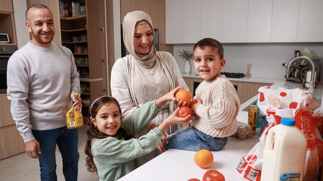 Dr Ned Khodragha with his wife Najah Elhassan and children Malak, 6, and Younes, 3, at home, in Revesby Heights. The family will be impacted by rising power bills. Picture: Justin Lloyd.