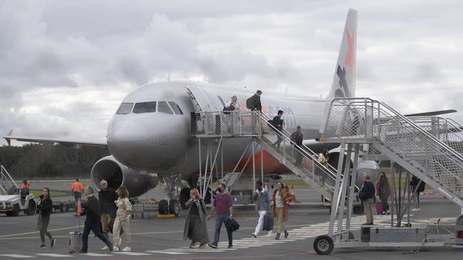 BYRON BAY, AUSTRALIA - JUNE 20: People disembark a domestic Jetstar flight at the Ballina-Byron Gateway Airport on June 20, 2020 in Byron Bay, Australia. Domestic tourists have started to return to Byron Bay following the easing of travel restrictions imposed due to the COVID-19 outbreak. All intrastate travel restrictions were lifted in NSW on June 1, allowing people to travel to regional areas within the state. Although borders between NSW, the ACT and Victoria remain open, Australians have been asked not to holiday interstate. Queensland, Western Australia and Tasmania's state borders remain closed, while South Australia is only open to travellers from WA, Tasmania and the Northern Territory while interstate arrivals to the Northern Territory must self isolate for 14 days. (Photo by Brook Mitchell/Getty Images)