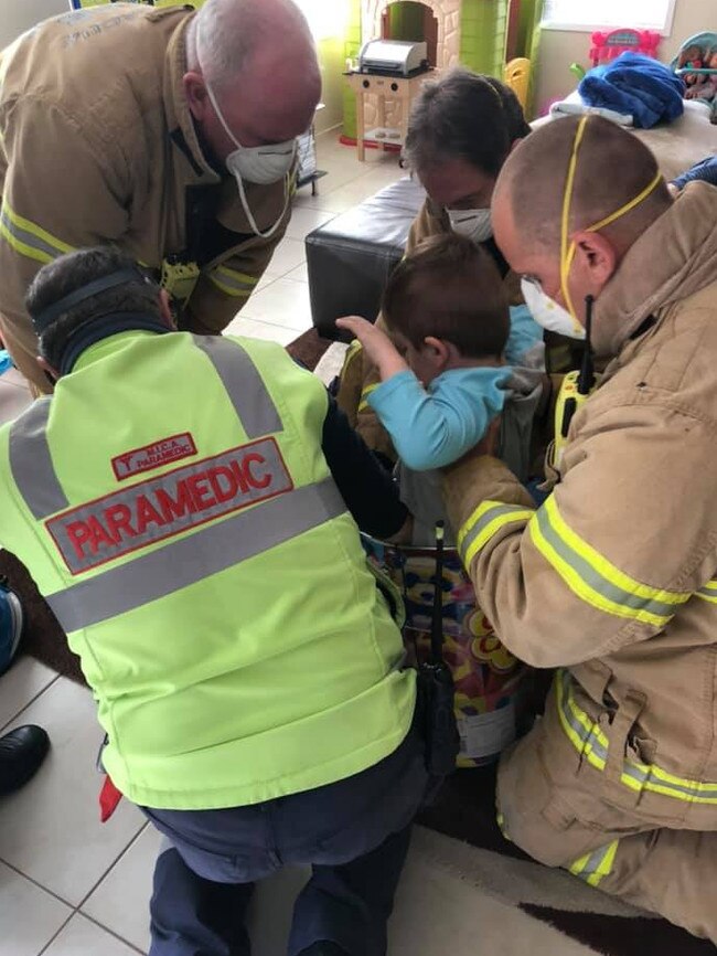 Firefighters work to free Alessio’s legs from the tin. Picture: Supplied.