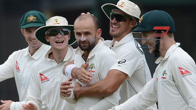 Australia’s Nathan Lyon (C) is congratulated after taking a wicket.