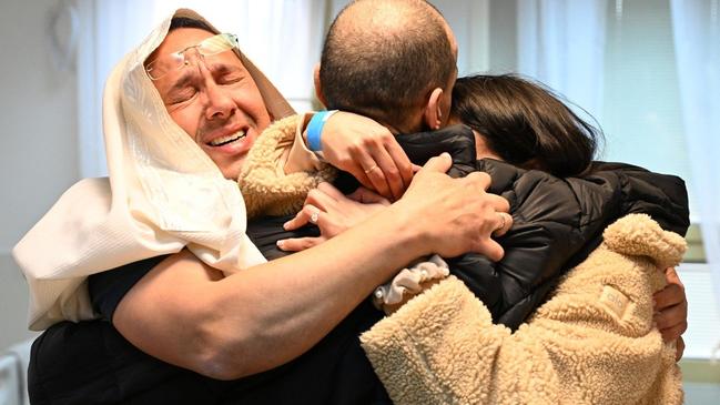 Eli Sharabi (with his back to camera) is embraced by his brother Sharon (left) at Sheba Medical Center near Tel Aviv, as he reunites with his family. Picture: AFP.