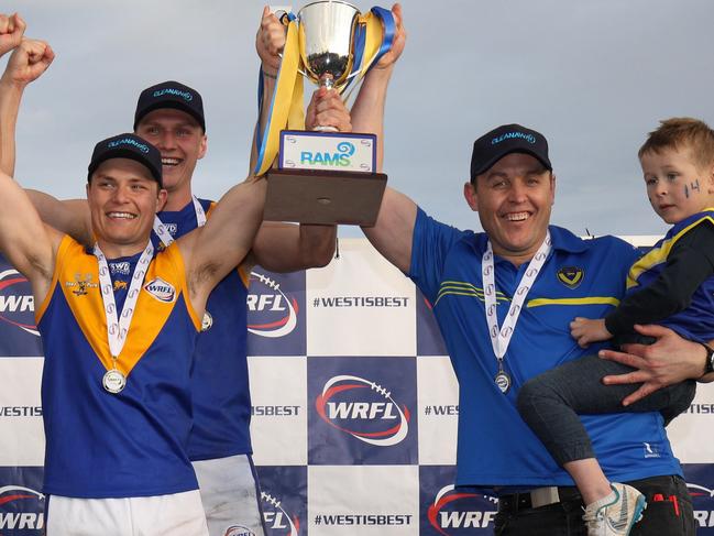 Jake McKenzie, captain Jack Purton-Smith and coach Marc Bullen hoist the silverware after Deer Park defeated Altona in the WRFL Division 1 grand final. Picture: Local Legends Photography